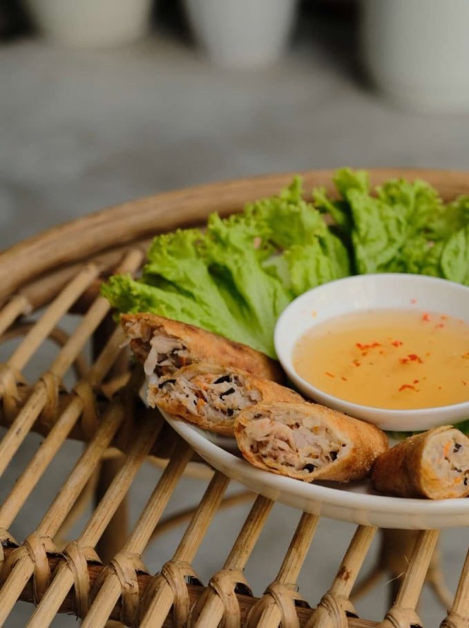 Fried spring rolls cut open, served with lettuce and a bowl of dipping sauce