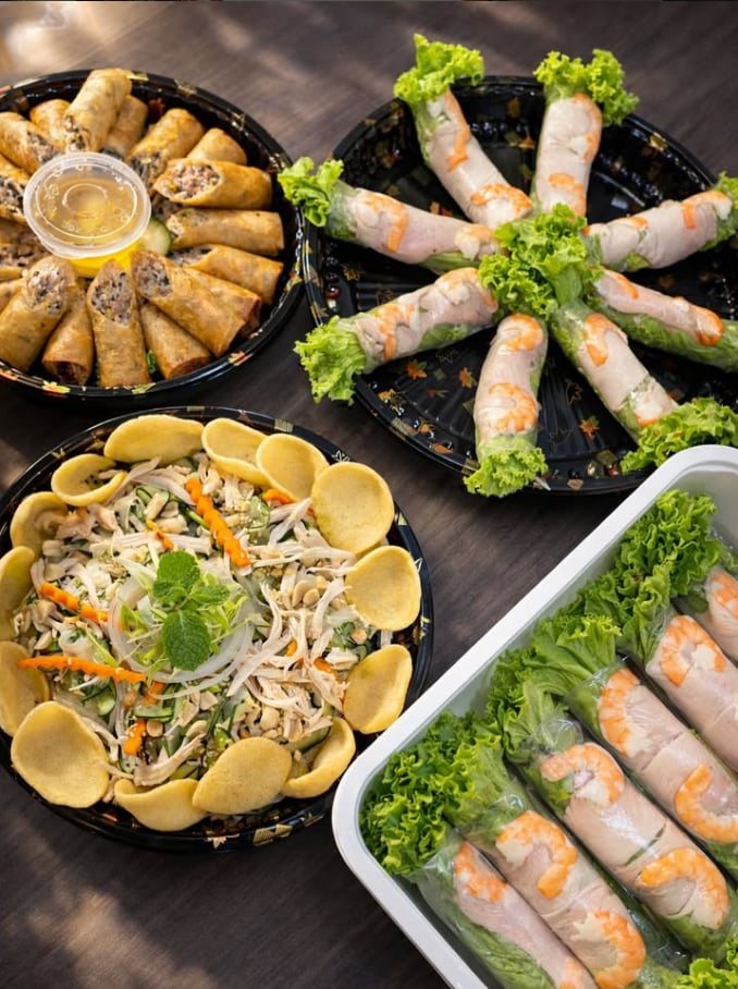 Platters of fried spring rolls, fresh shrimp rolls and a chicken salad topped with crackers